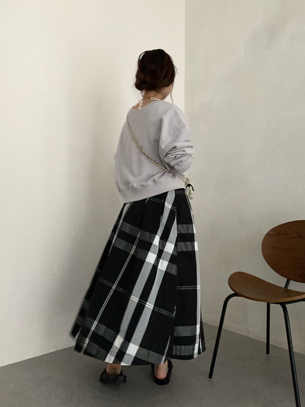ベージュ系のTシャツ/カットソー、ブラック系のスカート、ホワイト系のショルダーバッグを着用したレディースの春コーディネートの2枚目の写真
