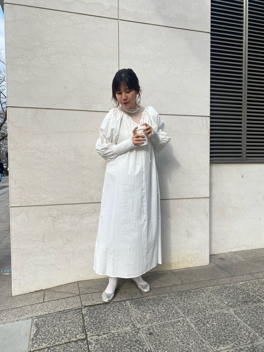 ホワイト系のワンピース、ホワイト系のTシャツ/カットソー、シルバー系のパンプスを着用したレディースの冬コーディネートの2枚目の写真