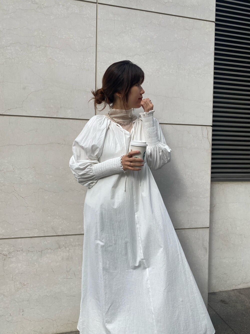 ホワイト系のワンピース、ホワイト系のTシャツ/カットソー、シルバー系のパンプスを着用したレディースの冬コーディネートの5枚目の写真