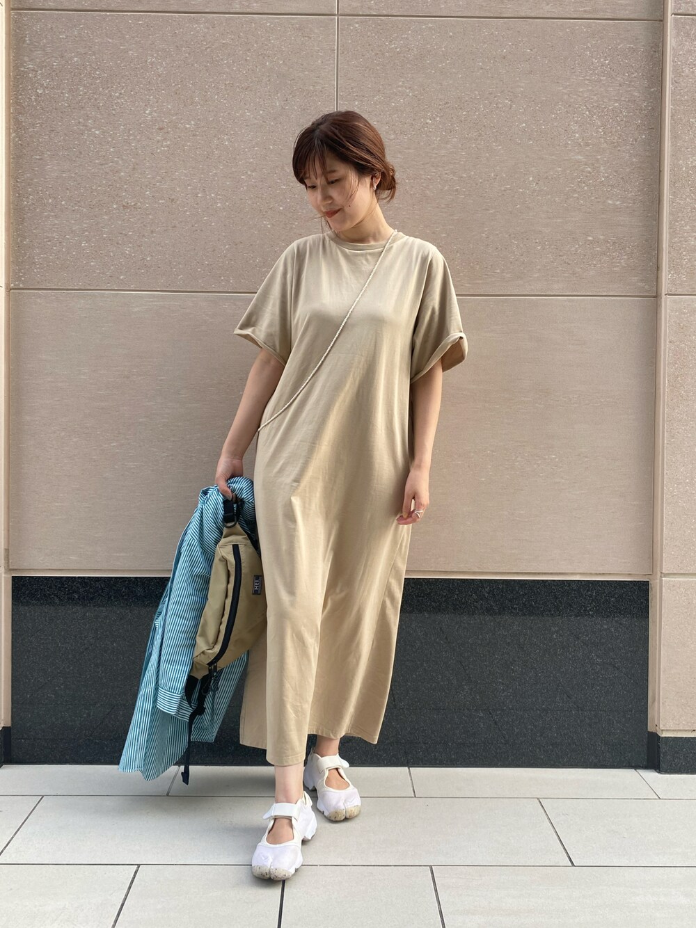 ホワイト系のスニーカー、ベージュ系のワンピース、グリーン系のバッグを着用したレディースの夏コーディネートの1枚目の写真