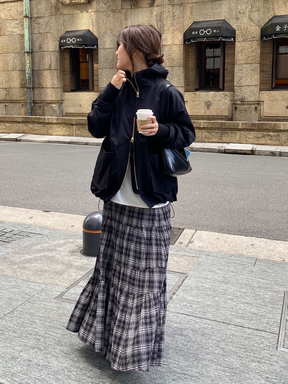 ブラック系のその他アウター、ホワイト系のTシャツ/カットソー、ブラック系のスカートを着用したレディースの春コーディネートの1枚目の写真