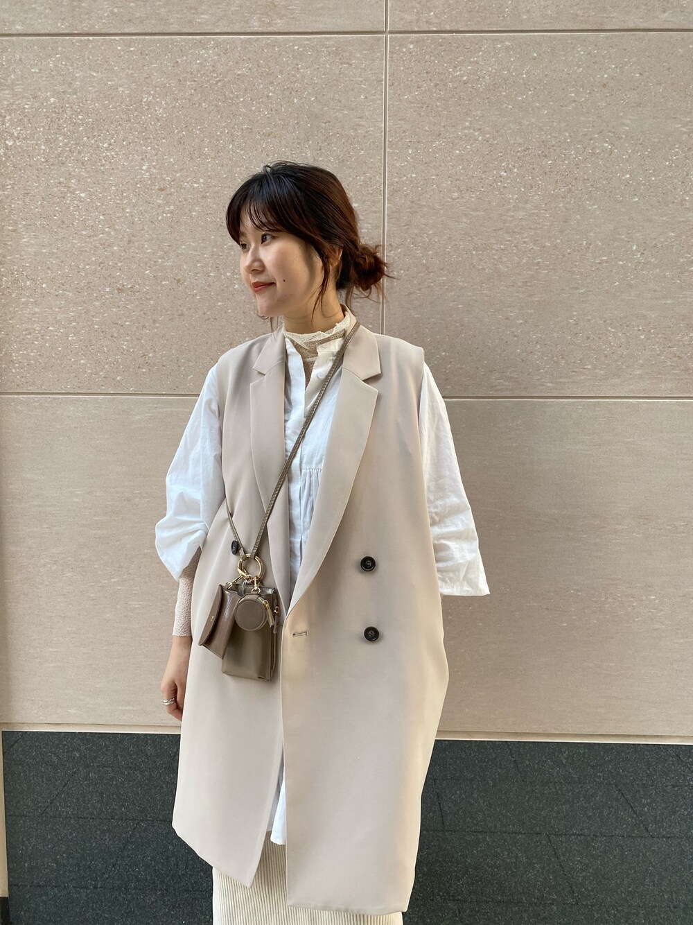 ベージュ系のベスト、ホワイト系のシャツ/ブラウス、ホワイト系のTシャツ/カットソーを着用したレディースの冬コーディネートの4枚目の写真