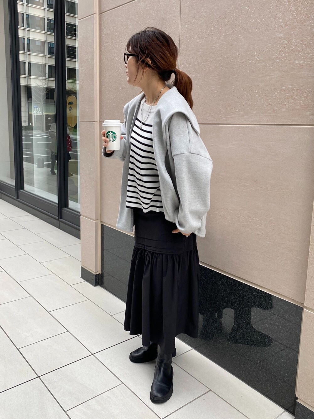 グレー系のその他アウター、ブラック系のニット/セーター、ブラック系のスカートを着用したレディースの冬コーディネートの4枚目の写真