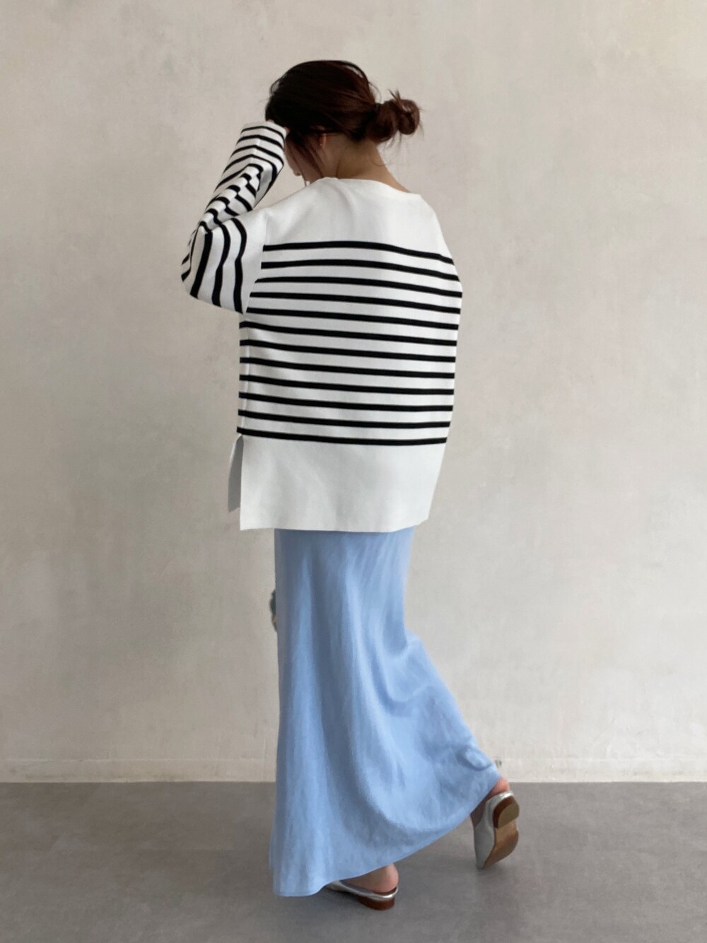 ブラック系のニット/セーター、ブルー系のスカート、ブルー系のショルダーバッグを着用したレディースの春コーディネートの4枚目の写真