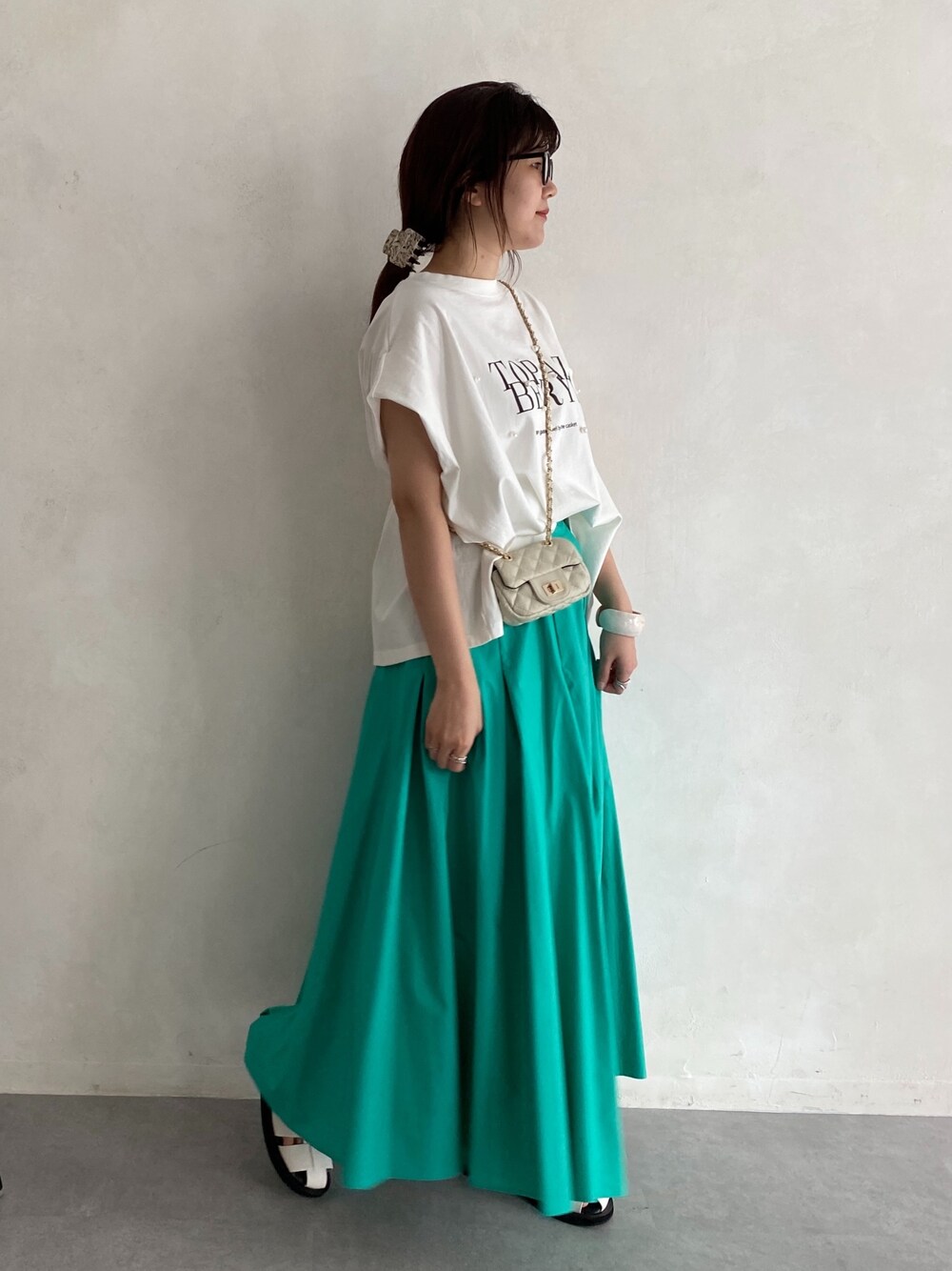 ホワイト系のTシャツ/カットソー、ブルー系のスカート、ホワイト系のショルダーバッグを着用したレディースの春コーディネートの3枚目の写真