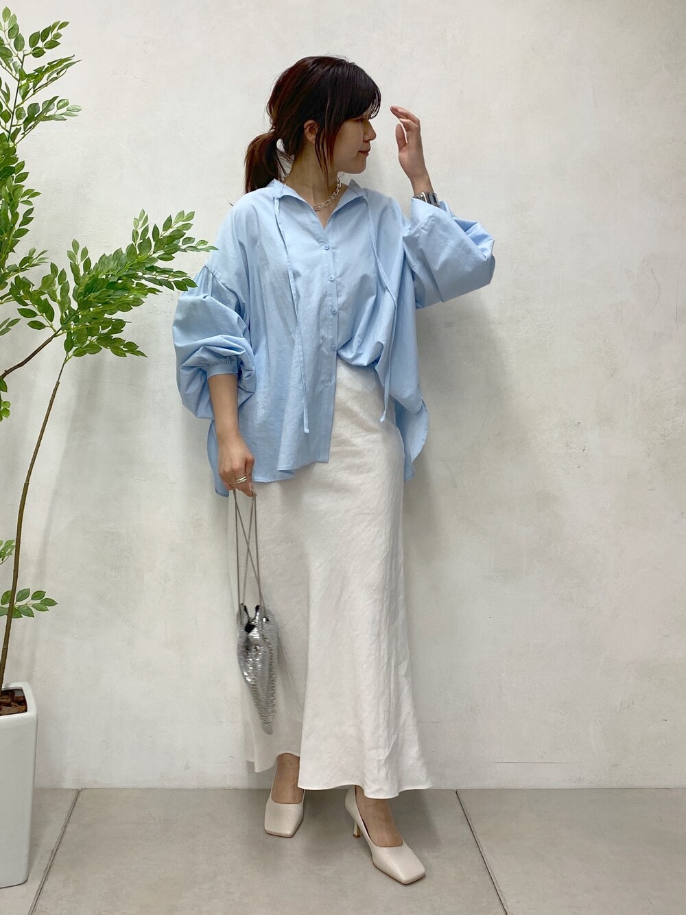 ブルー系のシャツ/ブラウス、ホワイト系のスカート、シルバー系のトートバッグを着用したレディースの春コーディネートの4枚目の写真