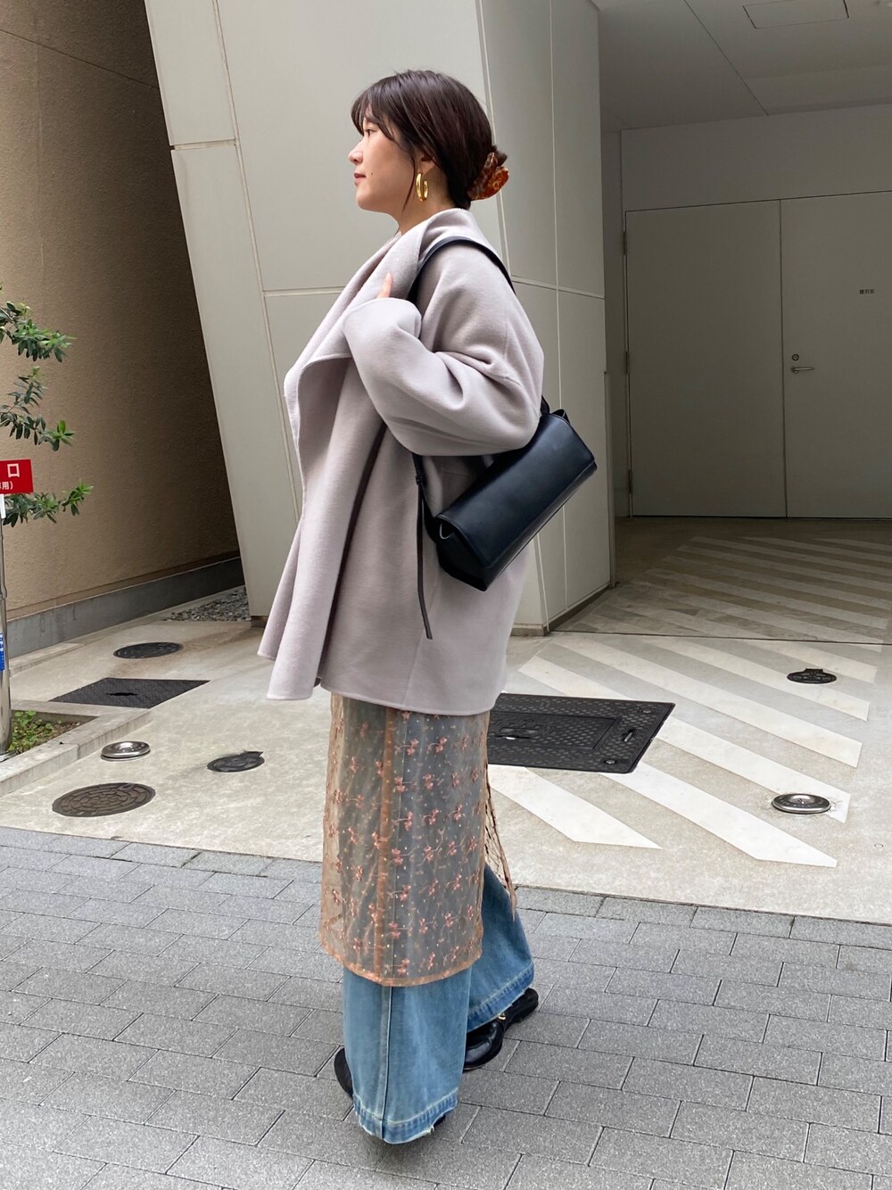 ベージュ系のその他アウター、ピンク系のスカート、ブルー系のデニムパンツを着用したレディースの冬コーディネートの1枚目の写真