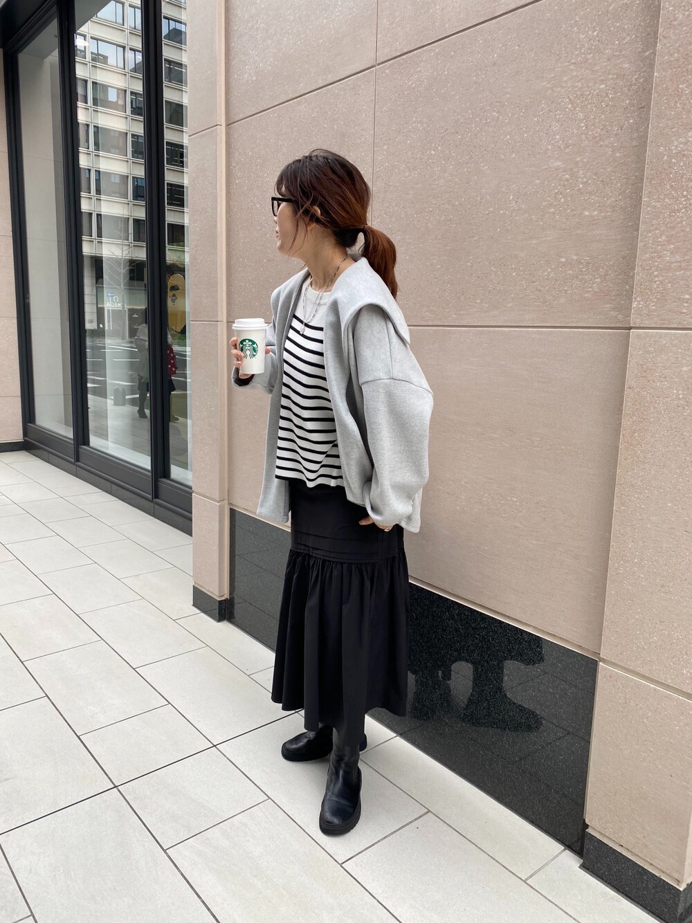 グレー系のその他アウター、ブラック系のニット/セーター、ブラック系のスカートを着用したレディースの冬コーディネートの2枚目の写真