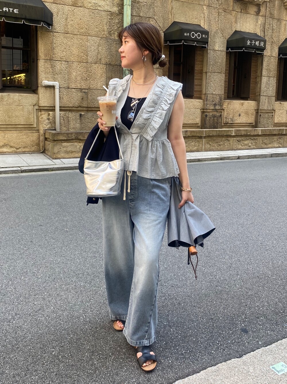 グレー系のシャツ/ブラウス、ブルー系のデニムパンツ、シルバー系のショルダーバッグを着用したレディースの夏コーディネートの1枚目の写真