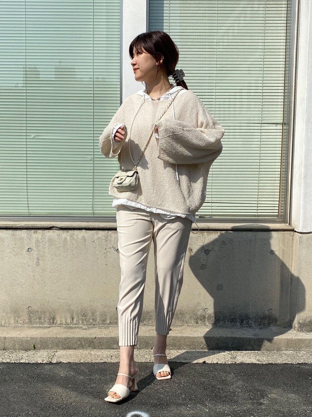 ホワイト系のニット/セーター、ホワイト系のシャツ/ブラウス、ベージュ系のその他パンツを着用したレディースの春コーディネートの2枚目の写真