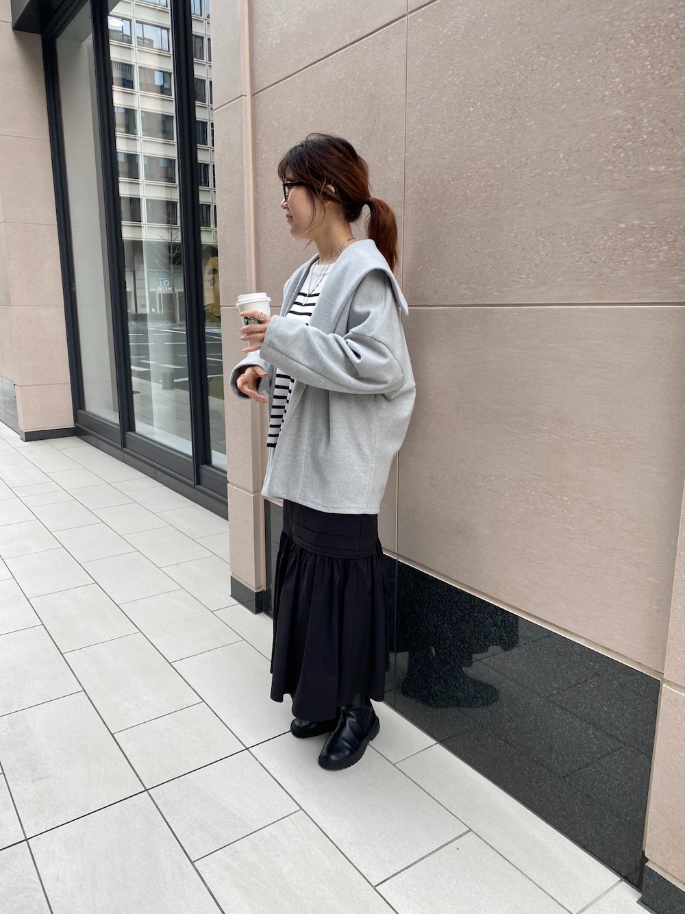 グレー系のその他アウター、ブラック系のニット/セーター、ブラック系のスカートを着用したレディースの冬コーディネートの3枚目の写真