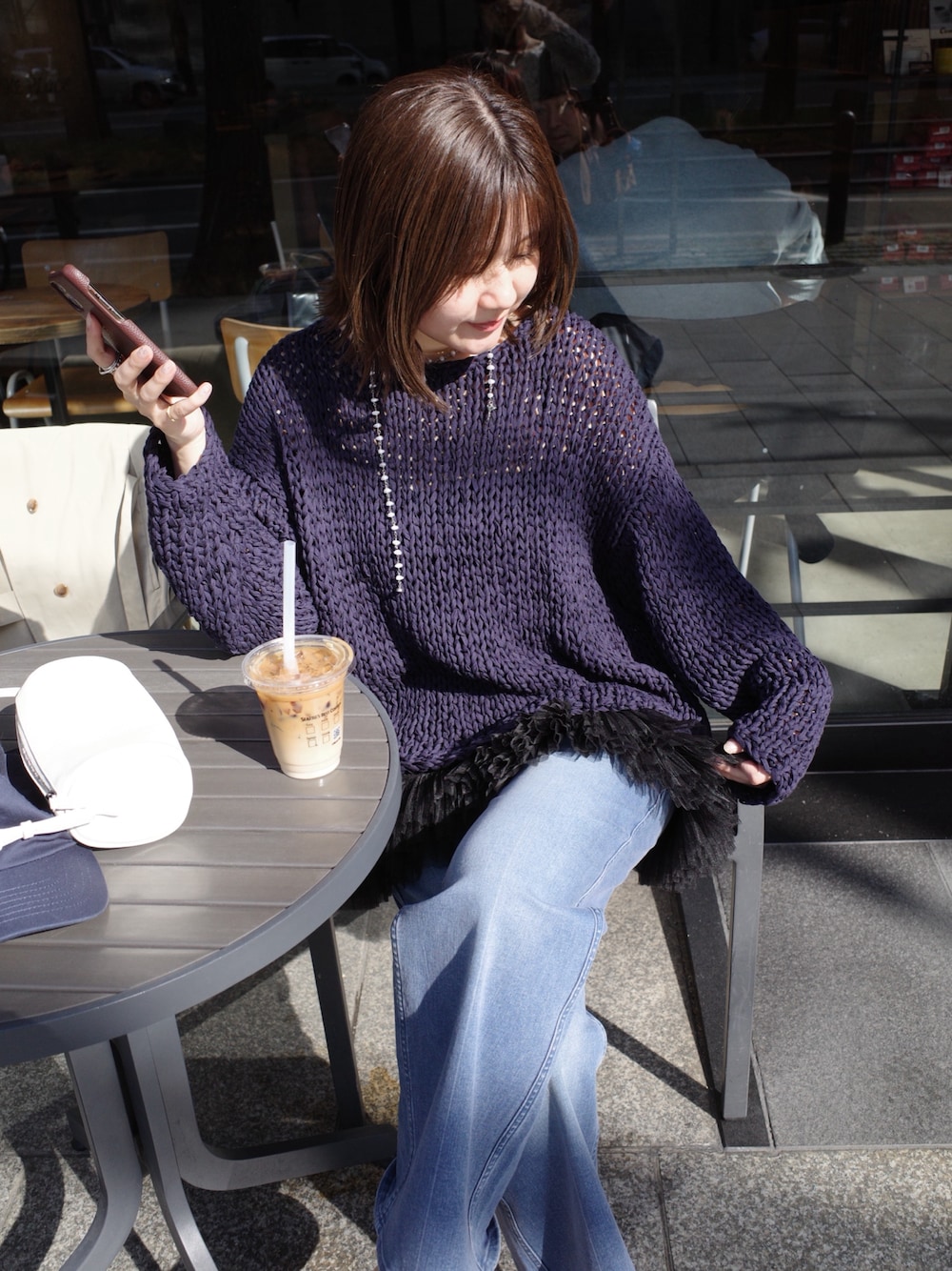 ブルー系のニット/セーター、ブラック系のシャツ/ブラウス、ブルー系のデニムパンツを着用したレディースの春コーディネートの1枚目の写真