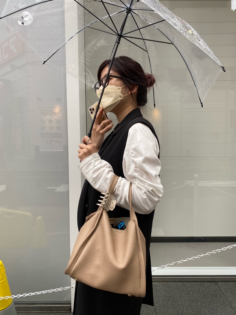 ブラック系のベスト、ホワイト系のTシャツ/カットソー、ベージュ系のスカートを着用したレディースの冬コーディネートの3枚目の写真