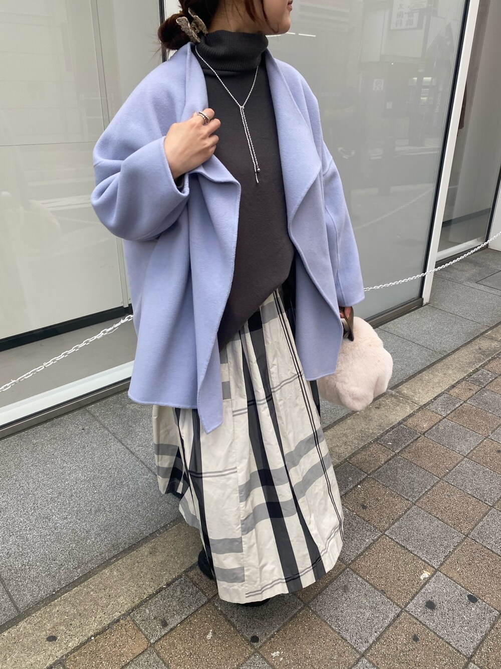 ブルー系のその他アウター、グレー系のニット/セーター、ホワイト系のスカートを着用したレディースの冬コーディネートの2枚目の写真