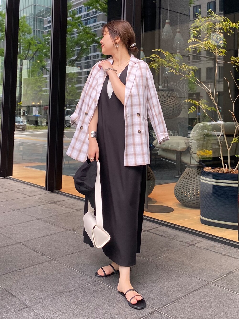 ホワイト系のテーラードジャケット、ブラック系のワンピースを着用したレディースの夏コーディネートの1枚目の写真