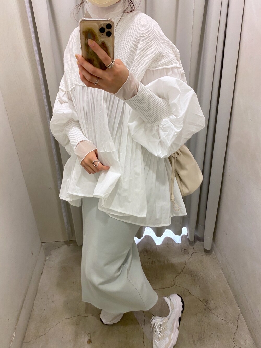 ホワイト系のTシャツ/カットソー、ベージュ系のステンカラーコート、ホワイト系のニット/セーターを着用したレディースの冬コーディネートの5枚目の写真