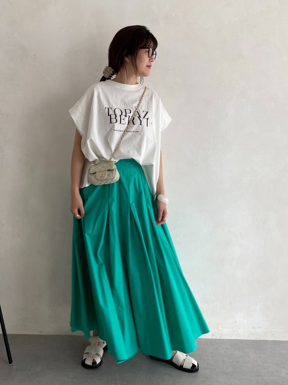 ホワイト系のTシャツ/カットソー、ブルー系のスカート、ホワイト系のショルダーバッグを着用したレディースの春コーディネートの4枚目の写真