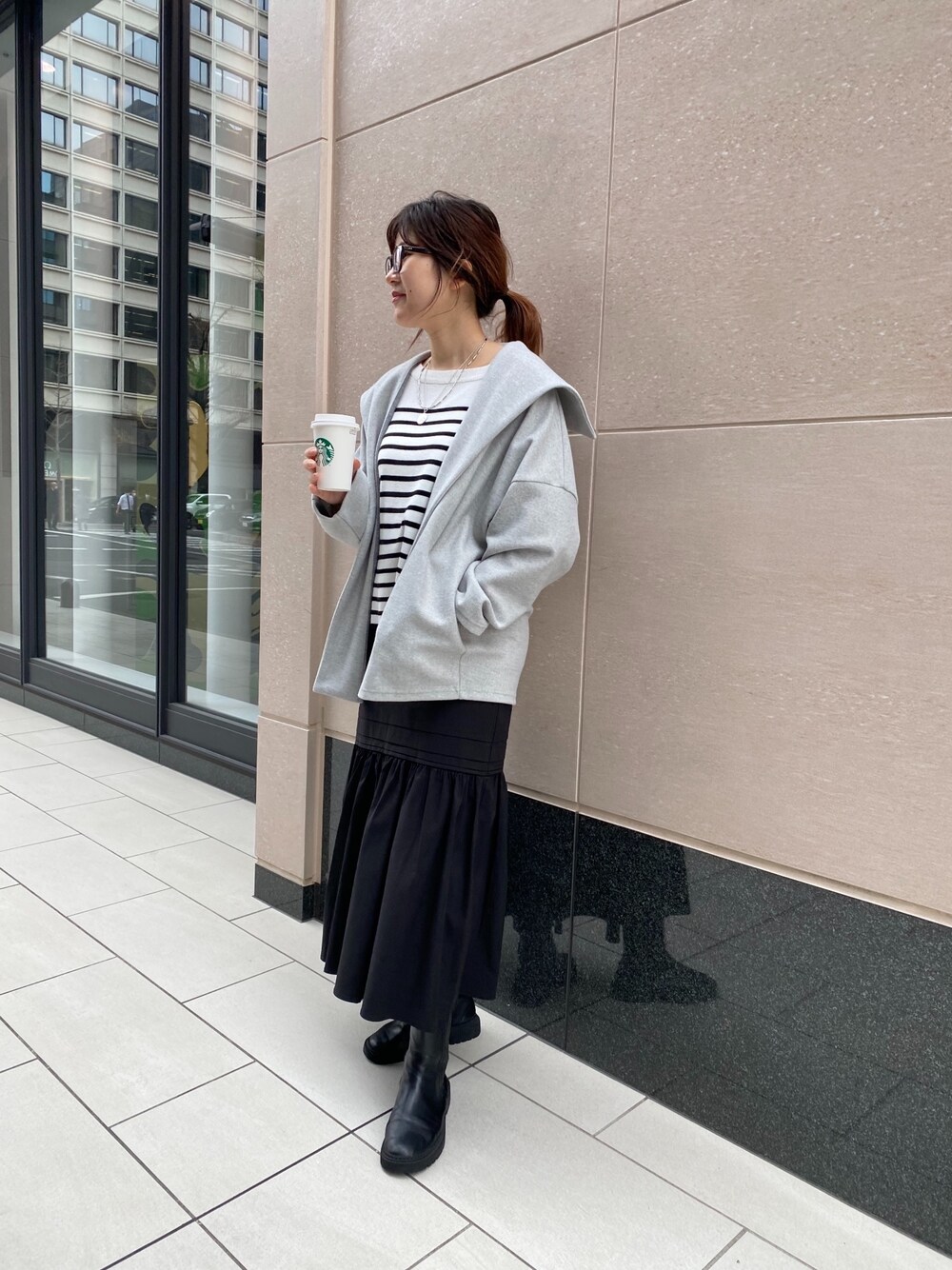 グレー系のその他アウター、ブラック系のニット/セーター、ブラック系のスカートを着用したレディースの冬コーディネートの4枚目の写真
