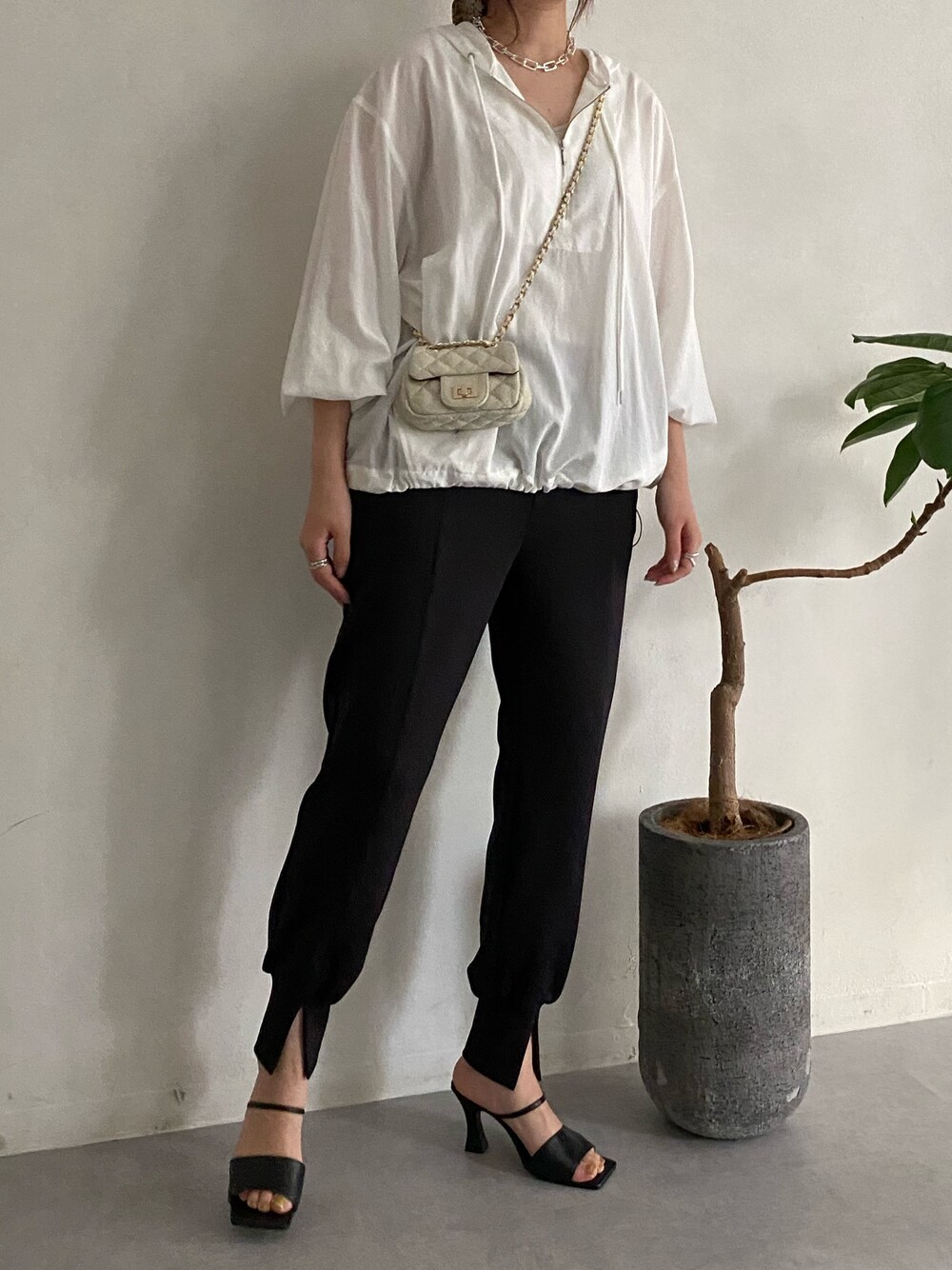 ホワイト系のシャツ/ブラウス、ホワイト系のショルダーバッグ、ブラック系のその他パンツを着用したレディースの春コーディネートの4枚目の写真