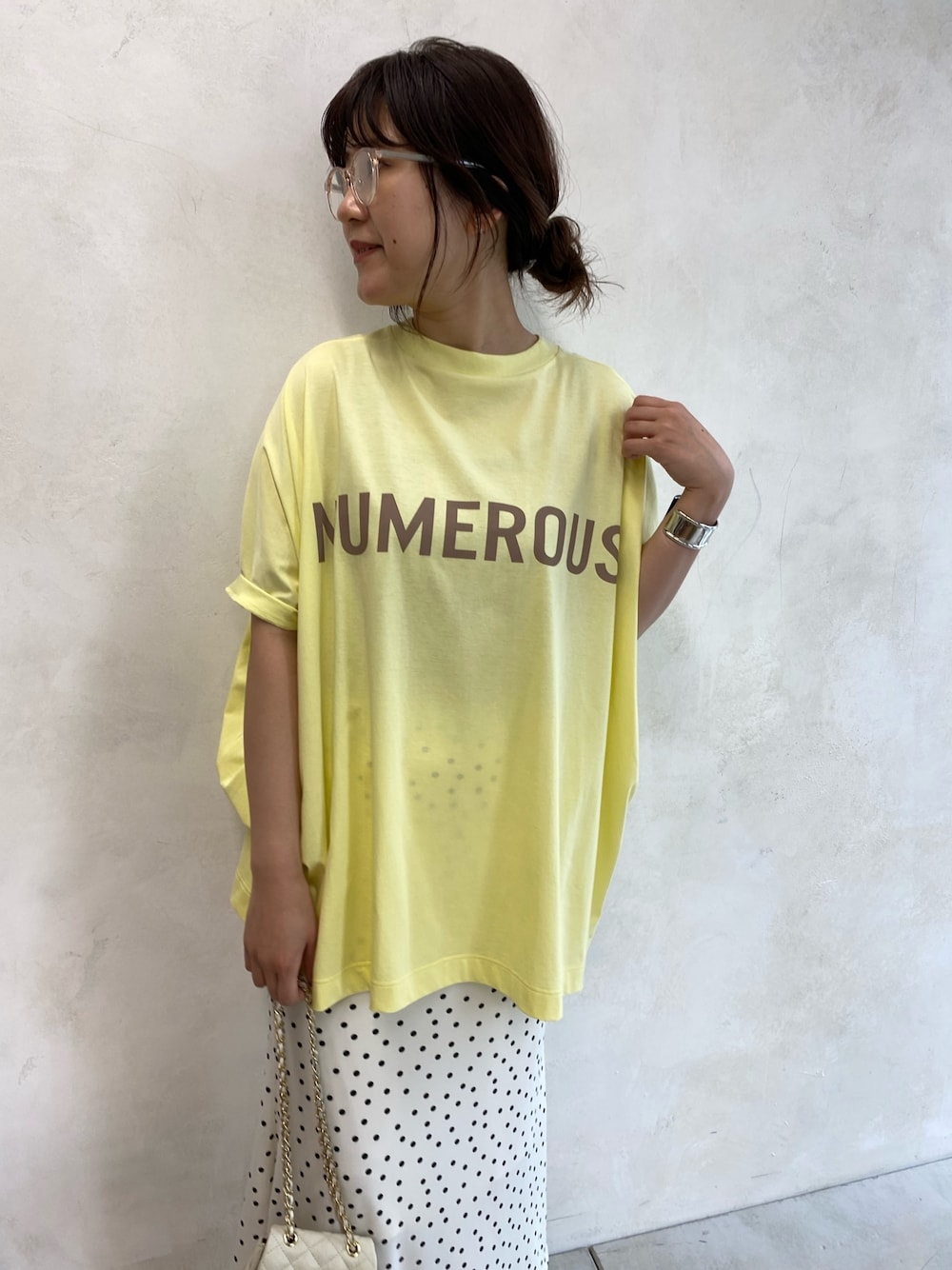 ホワイト系のサンダル、ホワイト系のショルダーバッグ、イエロー系のトップスを着用したレディースの春コーディネートの5枚目の写真