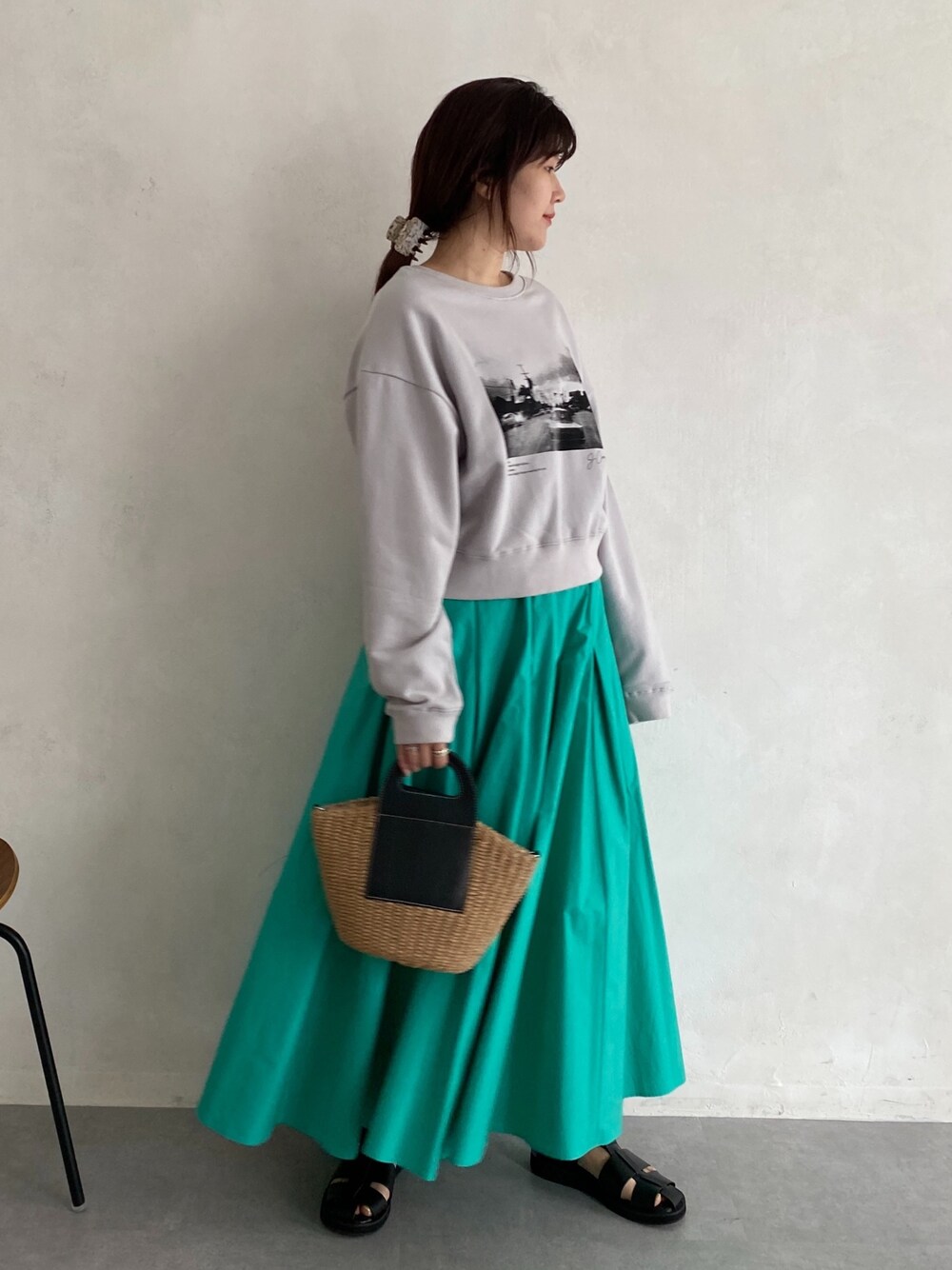 ベージュ系のTシャツ/カットソー、ブルー系のスカート、ブラック系のサンダルを着用したレディースの春コーディネートの2枚目の写真