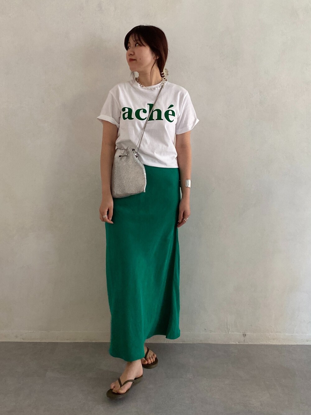 ホワイト系のTシャツ/カットソー、シルバー系のトートバッグ、グリーン系のスカートを着用したレディースの春コーディネートの4枚目の写真