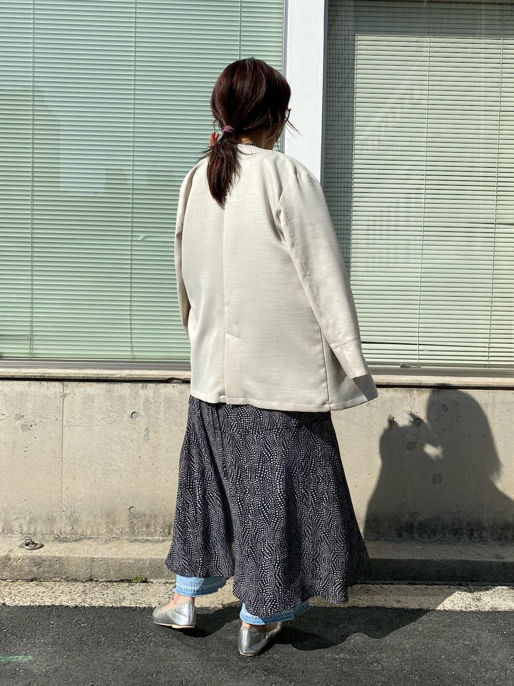 ベージュ系のノーカラージャケット、ブルー系のショルダーバッグ、ホワイト系のワンピースを着用したレディースの春コーディネートの3枚目の写真