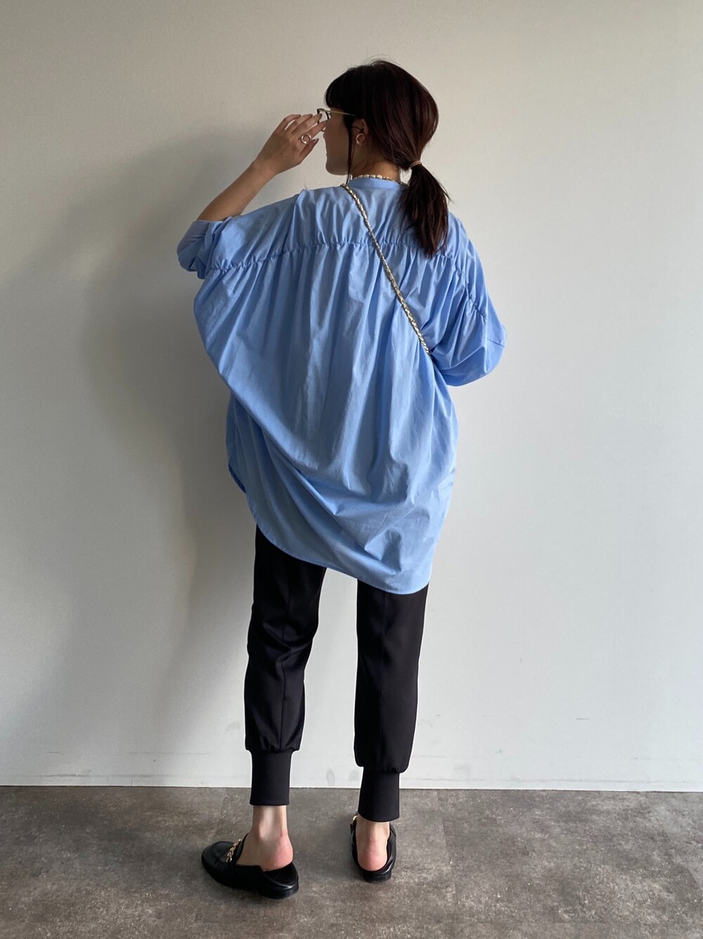 ホワイト系のショルダーバッグ、ブルー系のシャツ/ブラウス、ブラック系のその他パンツを着用したレディースの春コーディネートの4枚目の写真