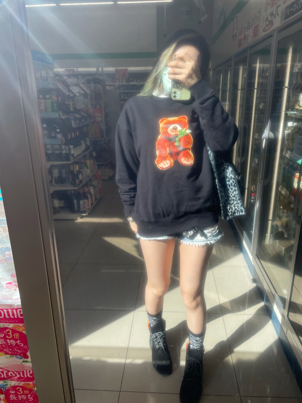 ブラック系のスウェット、ブラック系のショルダーバッグ、ブルー系のデニムパンツを着用したレディースの秋コーディネートの1枚目の写真