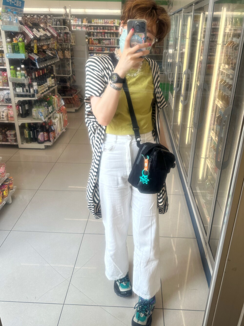 グリーン系のTシャツ/カットソー、ブラック系のカーディガン/ボレロ、ブラック系のショルダーバッグを着用したレディースの春コーディネートの1枚目の写真