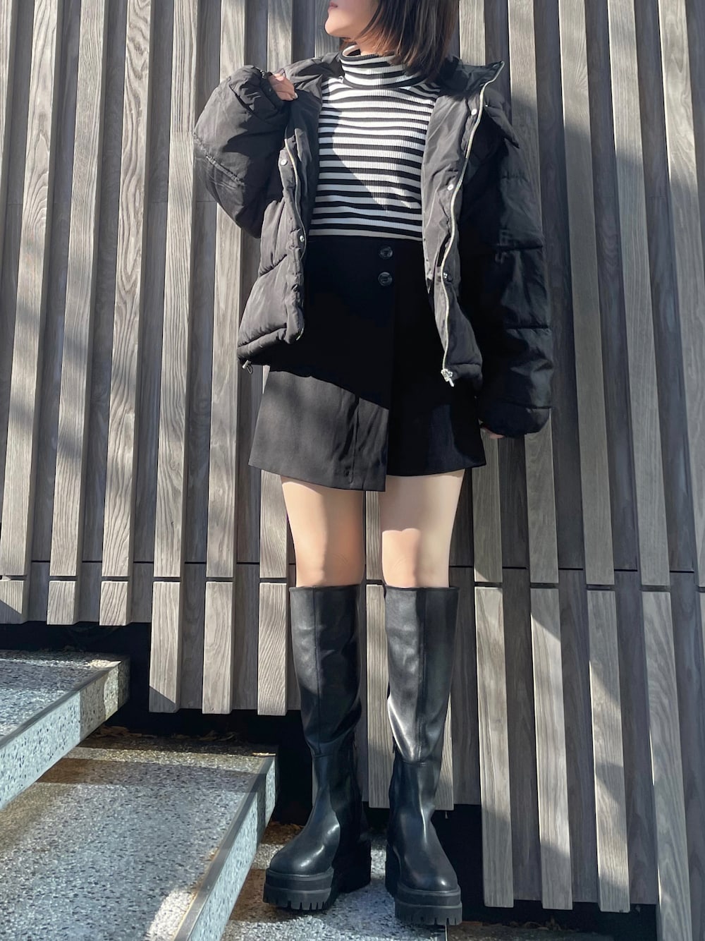 ブラック系のブーツ、ブラック系のTシャツ/カットソー、ブラック系のダウンジャケット/コートを着用したレディースの冬コーディネートの1枚目の写真