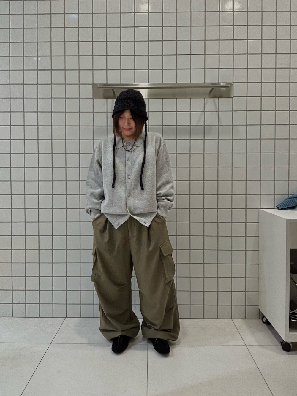 グレー系のカーディガン/ボレロ、グリーン系のカーゴパンツ、ブラック系のスニーカーを着用したレディースの冬コーディネートの1枚目の写真