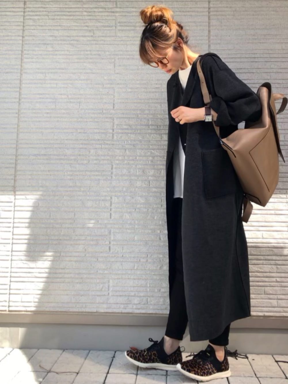 グレー系のノーカラーコート、ベージュ系のスニーカーを着用したレディースの冬コーディネートの1枚目の写真