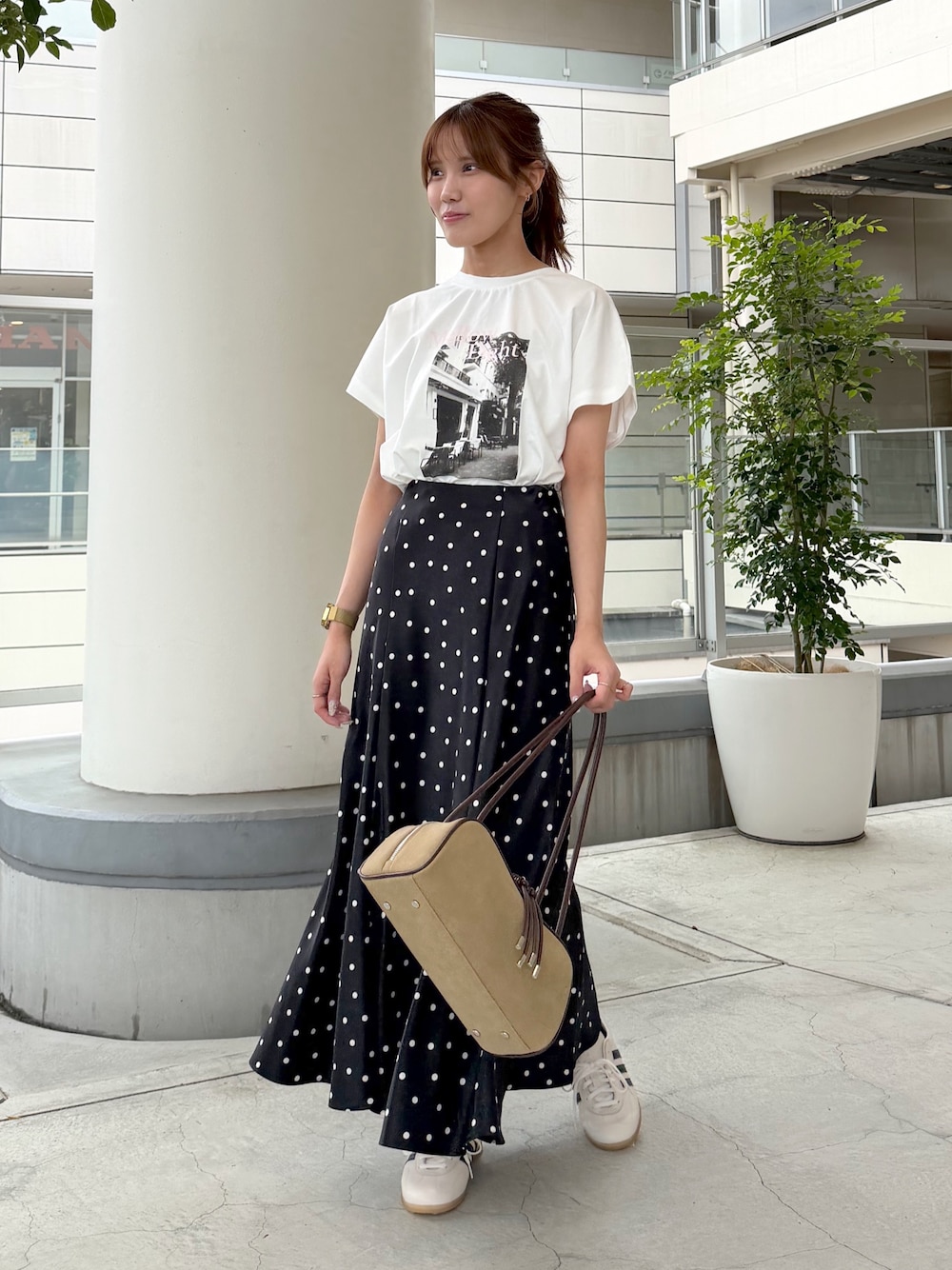 ホワイト系のTシャツ/カットソー、ブラック系のスカート、ベージュ系のボストンバッグを着用したレディースの夏コーディネートの1枚目の写真