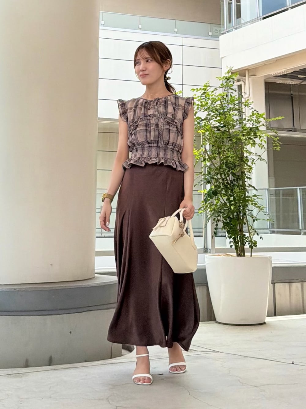 ブラウン系のスカート、ベージュ系のシャツ/ブラウス、ホワイト系のボストンバッグを着用したレディースの夏コーディネートの1枚目の写真