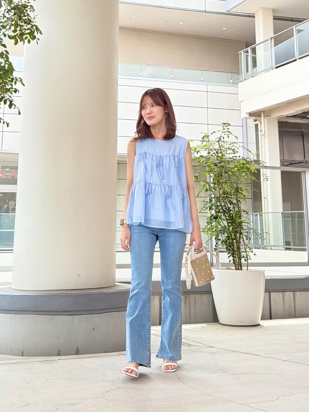 ブルー系のシャツ/ブラウス、ブルー系のデニムパンツ、ホワイト系のショルダーバッグを着用したレディースの夏コーディネートの1枚目の写真
