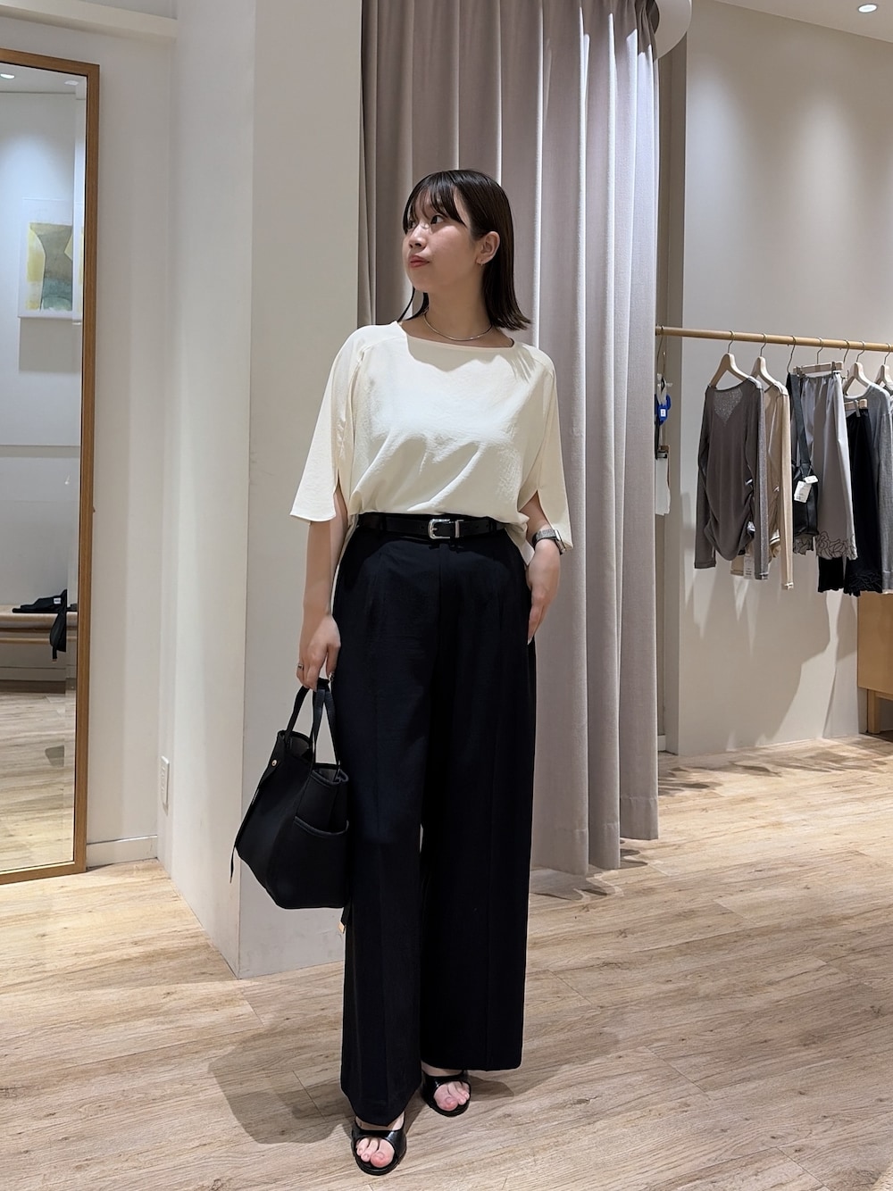 ブラック系のスラックス、ホワイト系のシャツ/ブラウス、ブラック系のトートバッグを着用したレディースの夏コーディネートの1枚目の写真