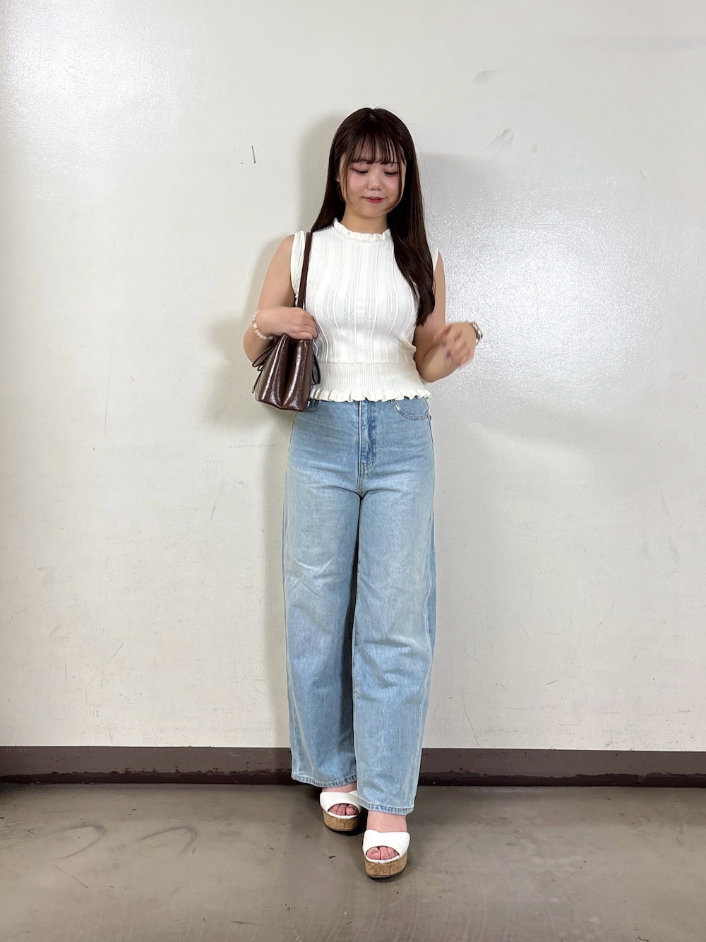 ブルー系のデニムパンツ、ホワイト系のニット/セーターを着用したレディースの夏コーディネートの1枚目の写真
