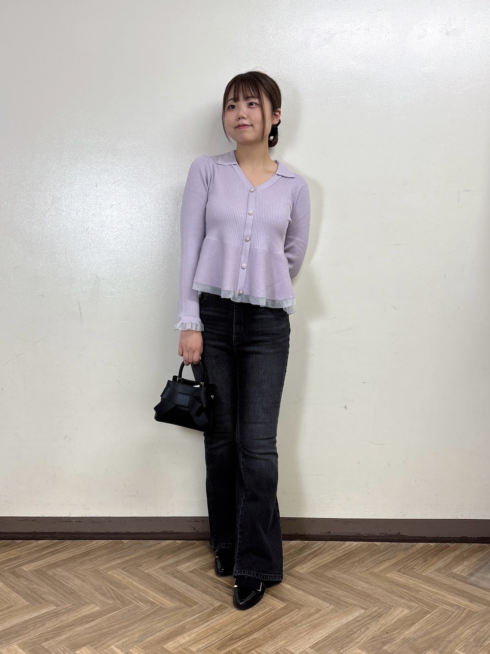 ブラック系のデニムパンツ、パープル系のニット/セーターを着用したレディースの秋コーディネートの1枚目の写真