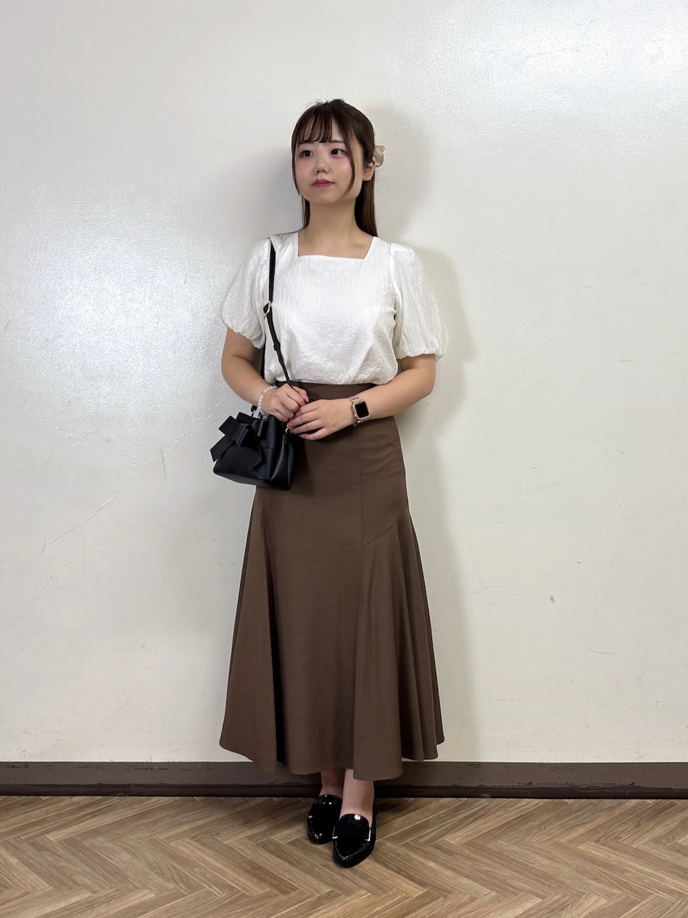 ブラウン系のスカート、ホワイト系のシャツ/ブラウスを着用したレディースの夏コーディネートの1枚目の写真