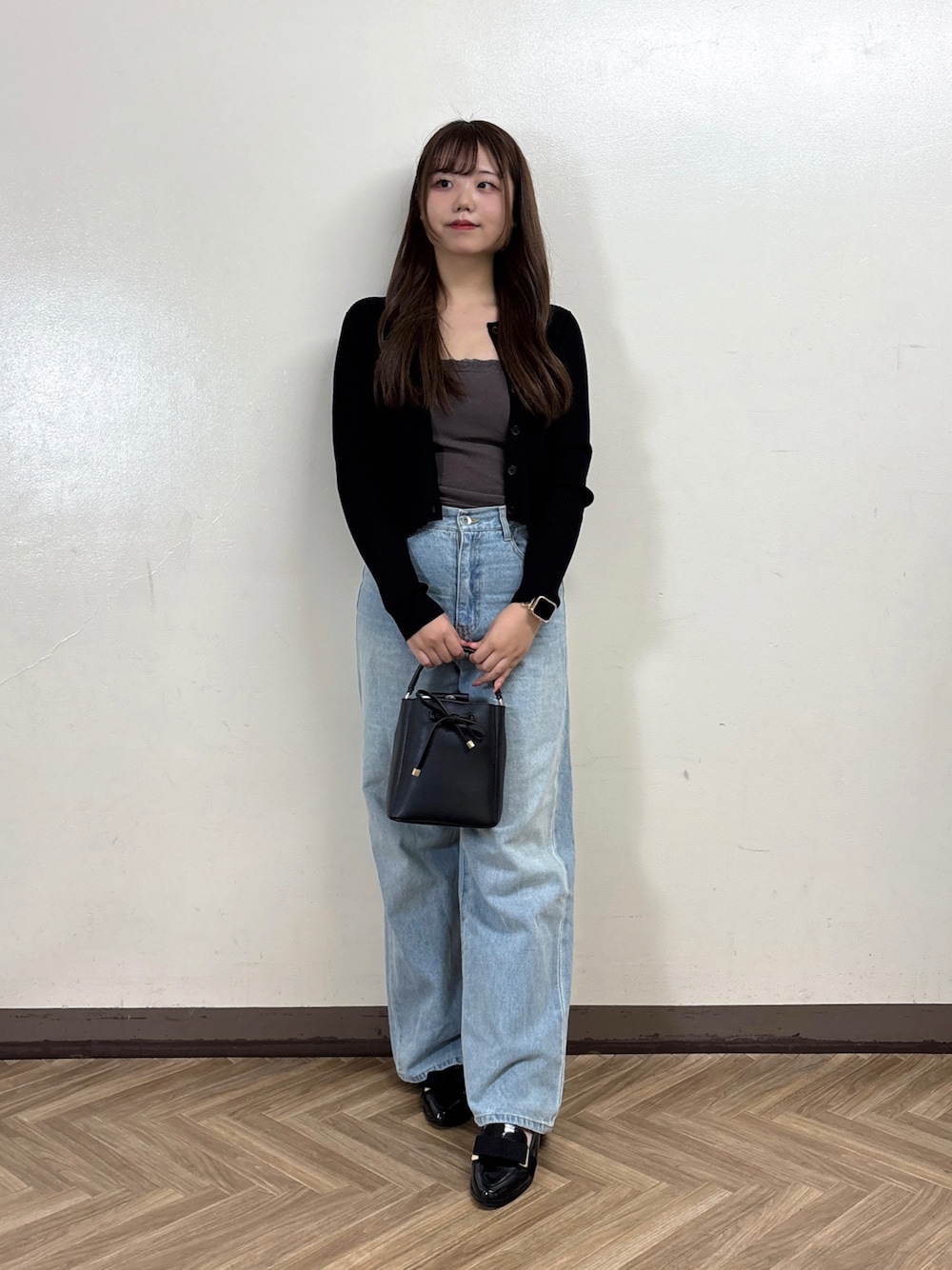 ブルー系のデニムパンツ、グレー系のTシャツ/カットソー、ブラック系のカーディガン/ボレロを着用したレディースの秋コーディネートの1枚目の写真