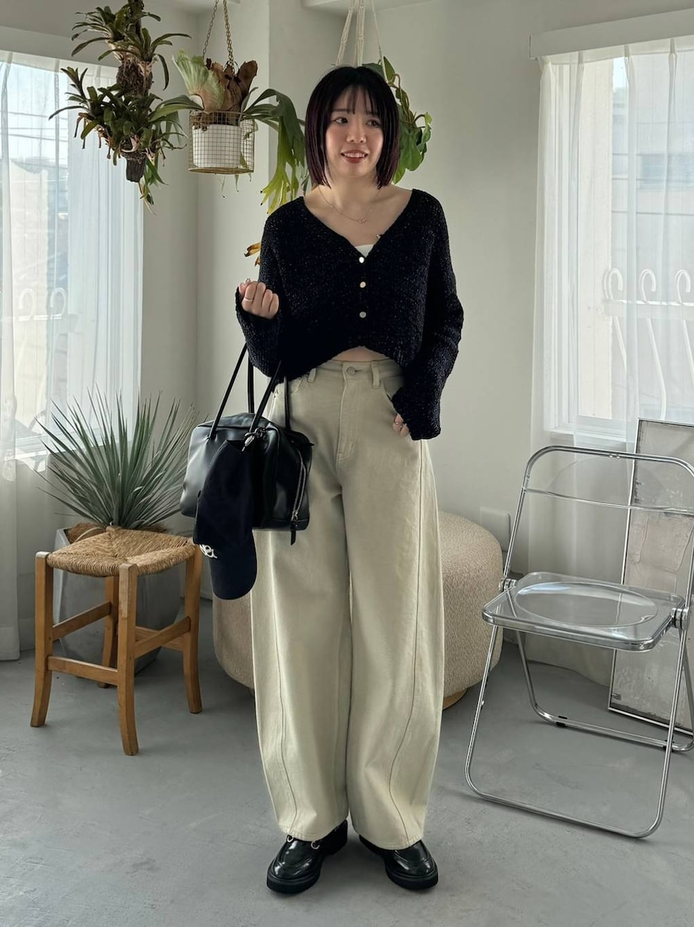 ベージュ系のデニムパンツ、ブラック系のボストンバッグ、ブラック系のローファーを着用したレディースの冬コーディネートの1枚目の写真