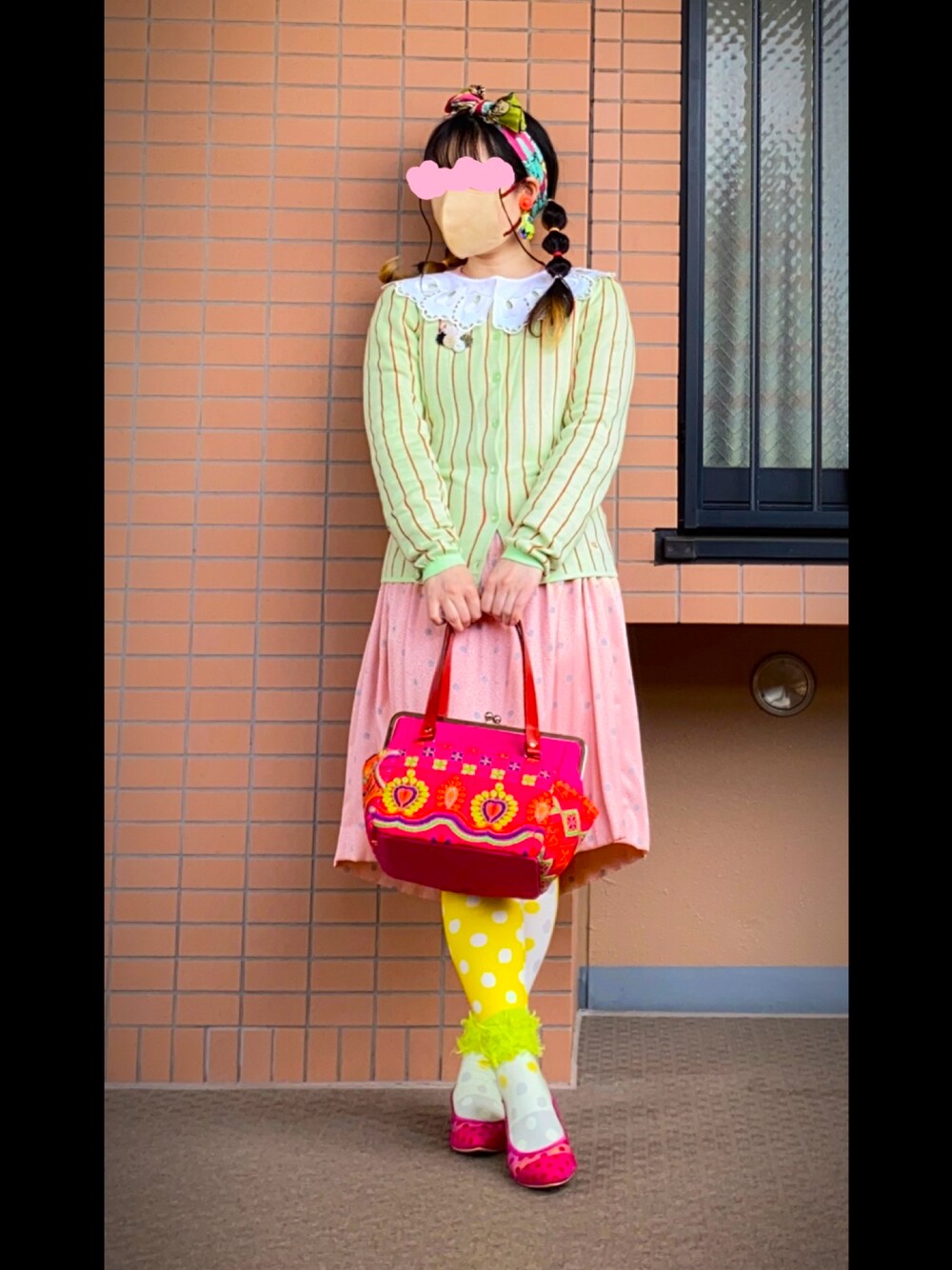 グリーン系のカーディガン/ボレロ、ピンク系のワンピース、ピンク系のバッグを着用したレディースの春コーディネートの1枚目の写真