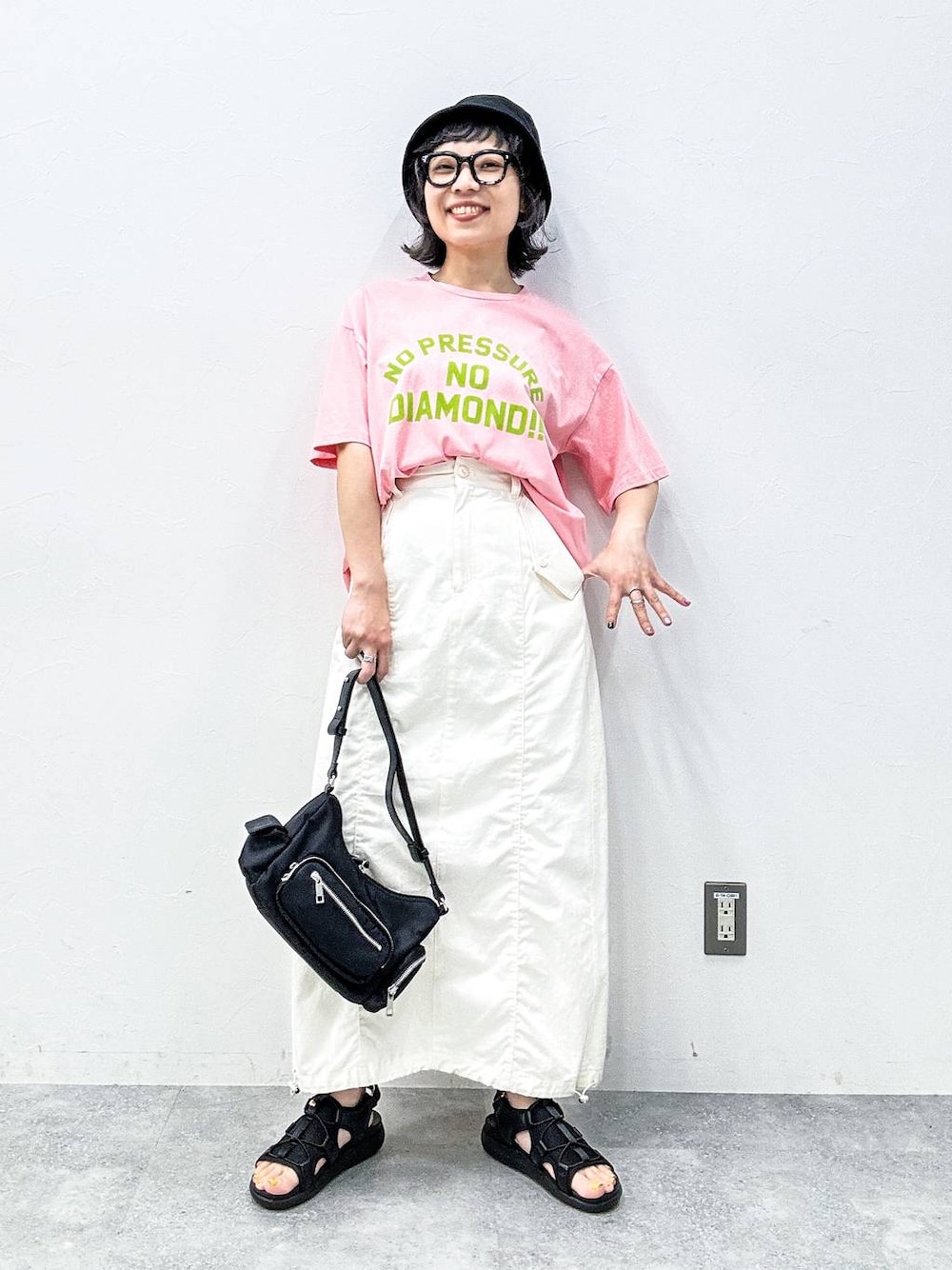 ホワイト系のスカート、ブラック系のサンダル、ピンク系のTシャツ/カットソーを着用したレディースの春コーディネートの1枚目の写真