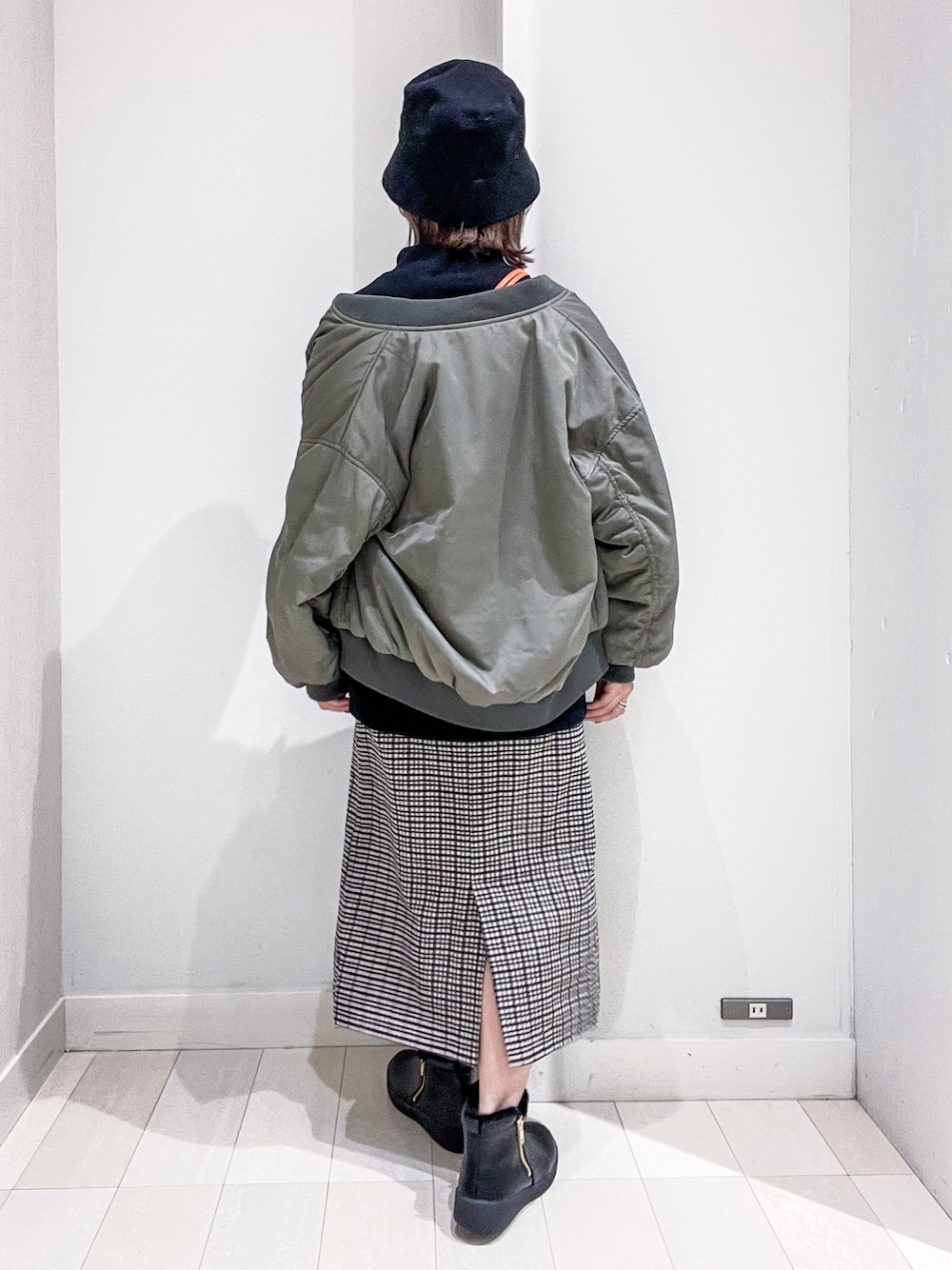 ブラック系のスウェット、グリーン系のMA-1、オレンジ系のショルダーバッグを着用したレディースの冬コーディネートの3枚目の写真