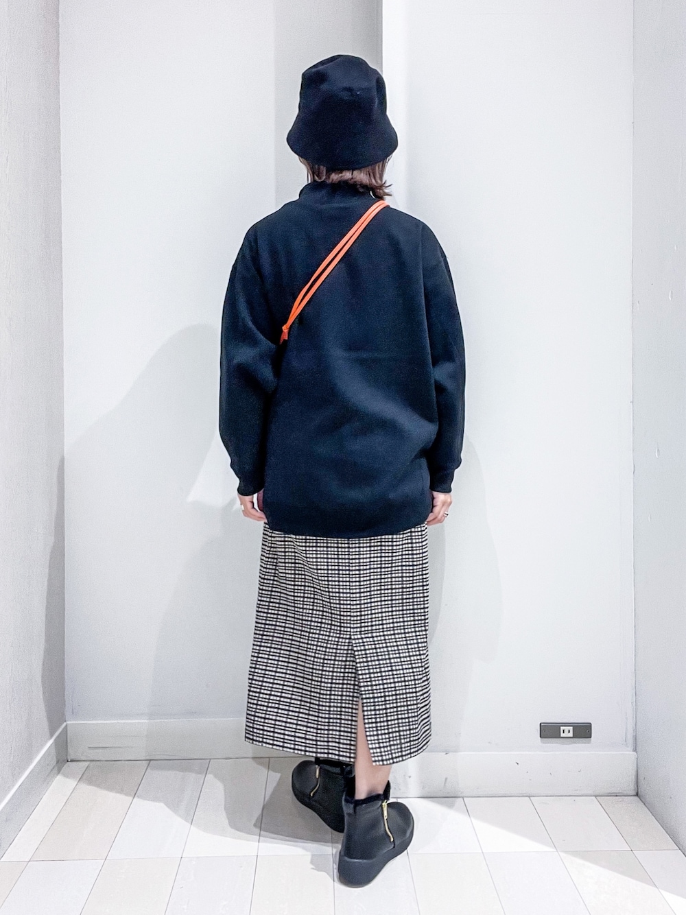 ブラック系のスウェット、グリーン系のMA-1、オレンジ系のショルダーバッグを着用したレディースの冬コーディネートの5枚目の写真