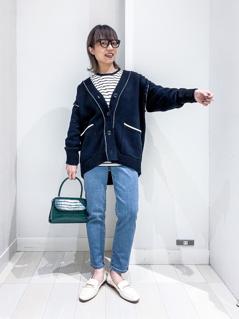 その他のTシャツ/カットソー、ブラック系のカーディガン/ボレロ、ブルー系のデニムパンツを着用したレディースの冬コーディネートの2枚目の写真