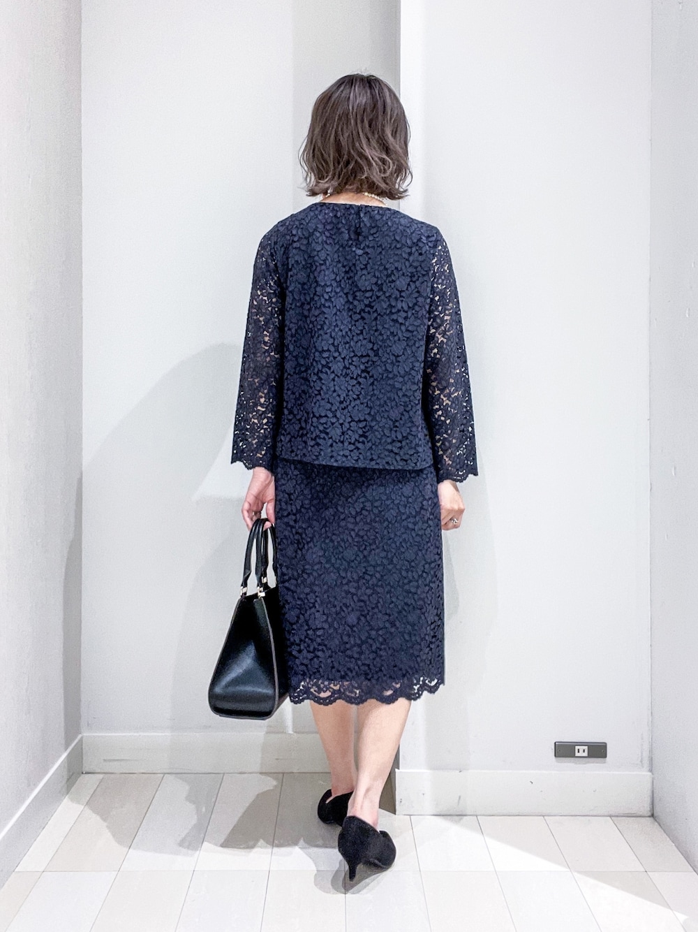 ブルー系のシャツ/ブラウス、グレー系のノーカラージャケット、ブルー系のスカートを着用したレディースの冬コーディネートの5枚目の写真