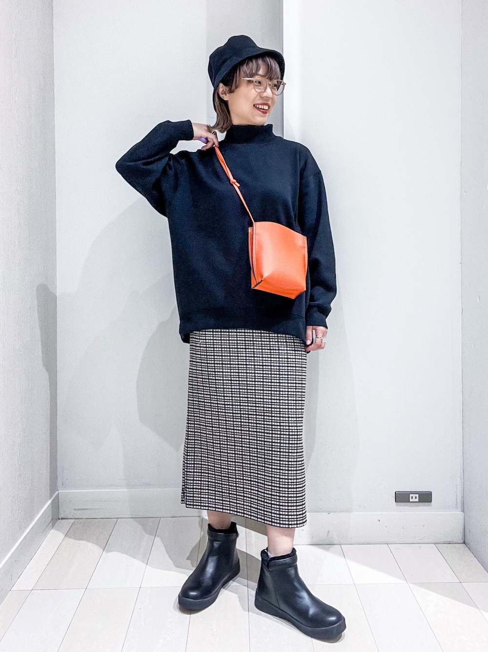 ブラック系のスウェット、グリーン系のMA-1、オレンジ系のショルダーバッグを着用したレディースの冬コーディネートの4枚目の写真