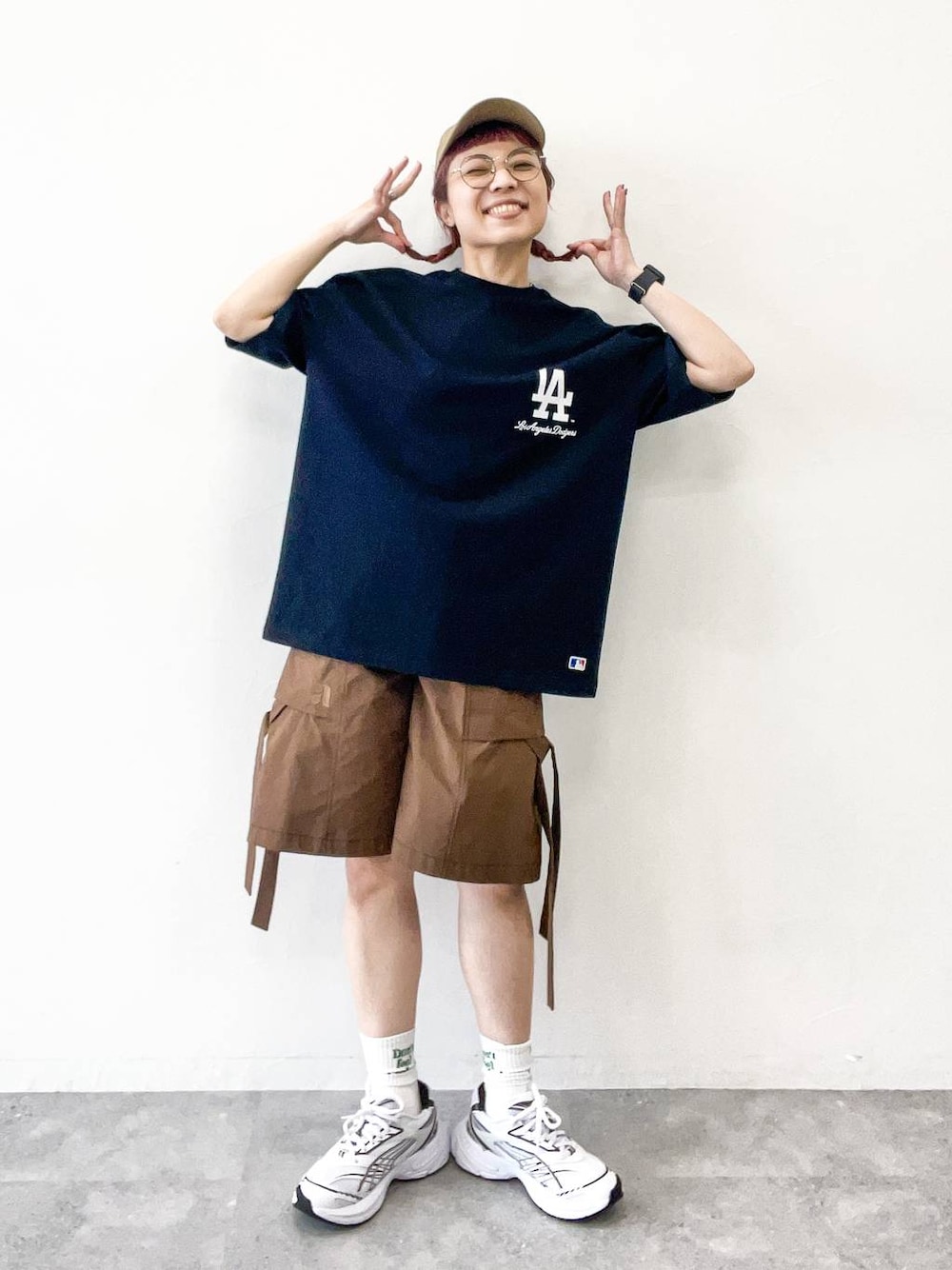 ブラウン系のカーゴパンツ、ブラック系のTシャツ/カットソー、ベージュ系のキャップを着用したレディースの夏コーディネートの1枚目の写真